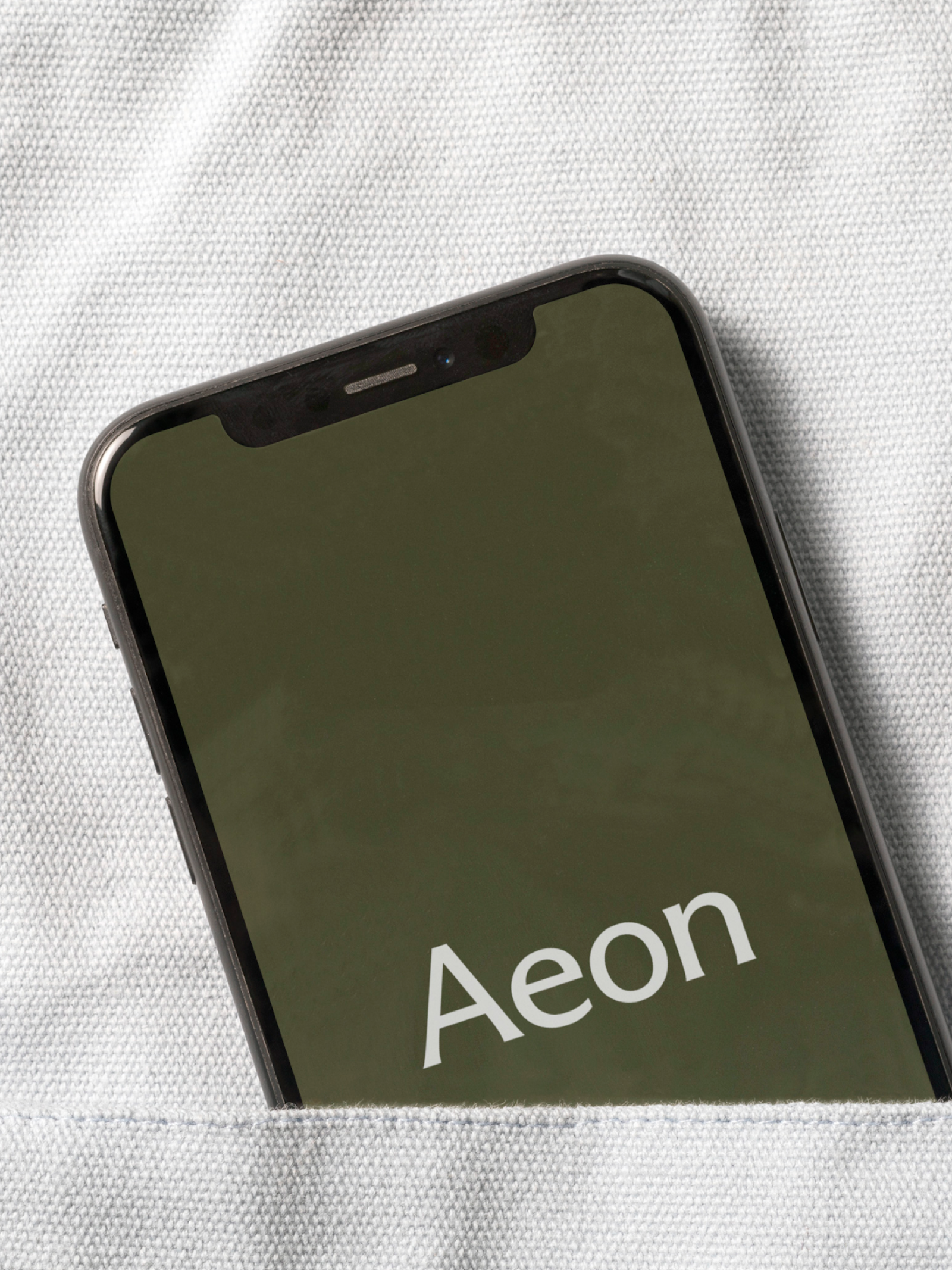 A close-up image of a white lab coat, shows the AEON logotype